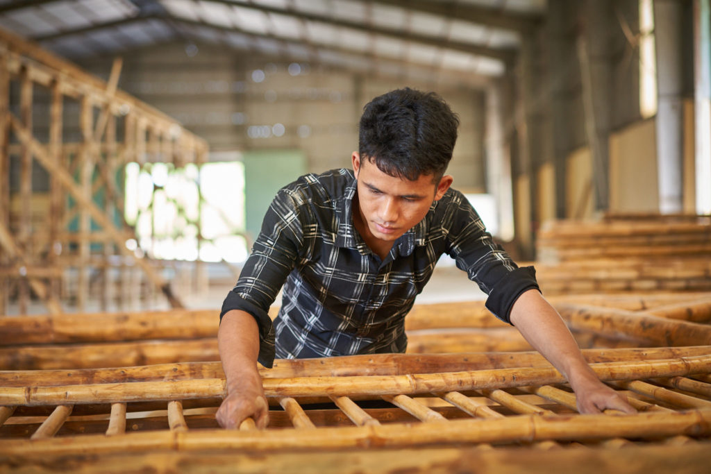 Craftsman shaping bamboo by hand in Vietnam