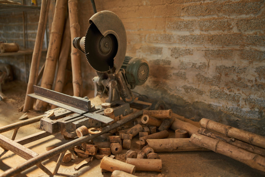 Worker moving bamboo poles through the workshop